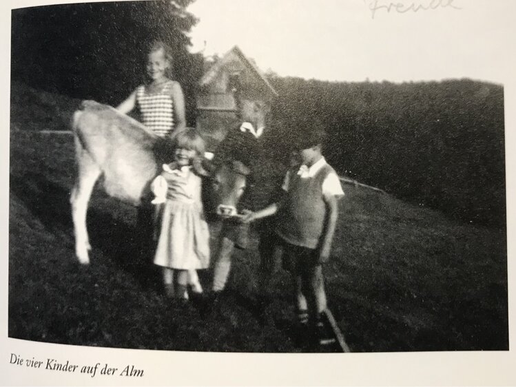 Four children on a mountain meadow, one holding a horse, all dressed in vintage attire. | © Urlaub am Bauernhof / Schell