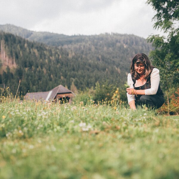 Frau kniet auf der Wiese | © Urlaub am Bauernhof Kärnten / Daniel Gollner