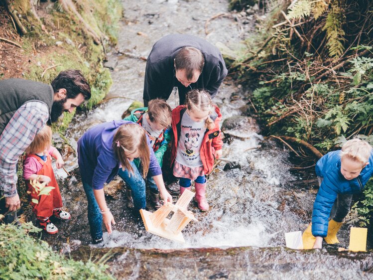 Familie im Bach mit Mühlrad | © Urlaub am Bauernhof Kärnten / Daniel Gollner