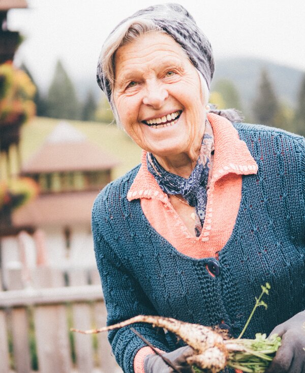 Frau mit Karotten in der Hand | © Urlaub am Bauernhof Kärnten / Daniel Gollner