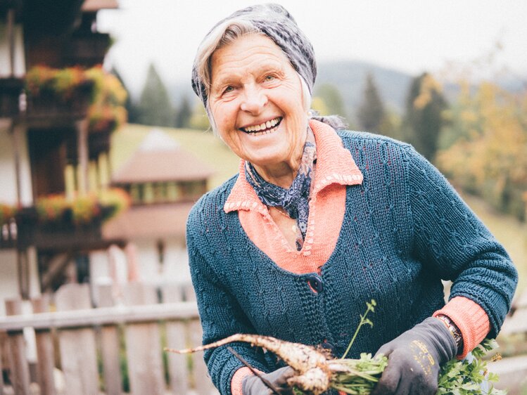 Frau mit Karotten in der Hand | © Urlaub am Bauernhof Kärnten / Daniel Gollner