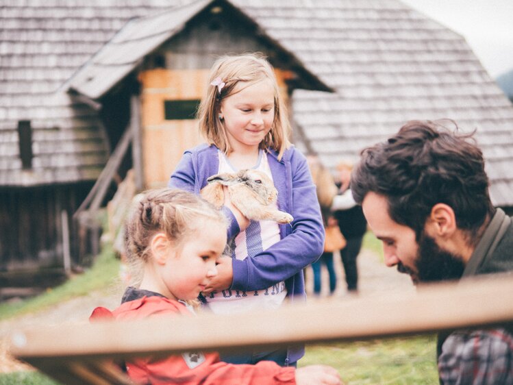 Mann und Kinder halten Hasen | © Urlaub am Bauernhof Kärnten/Daniel Gollner