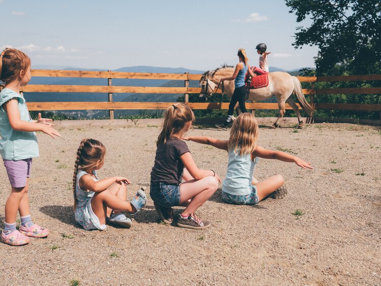 Frau führt Pferd im Viereck und Kinder schauen zu | © Urlaub am Bauernhof Kärnten / Daniel Gollner