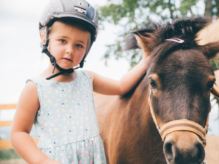Mädchen streichelt Pony | © Urlaub am Bauernhof Kärnten / Daniel Gollner