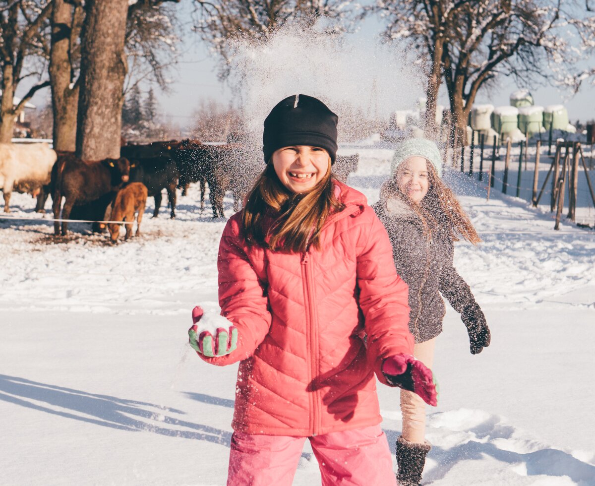 Kind mit Schneeball wird mit Schnee getroffen | © Urlaub am Bauernhof Kärnten/ Daniel Gollner