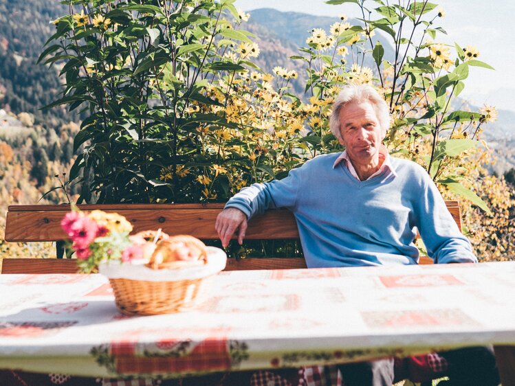 Mann sitzt beim Gartentisch | © Urlaub am Bauernhof Kärnten / Daniel Gollner