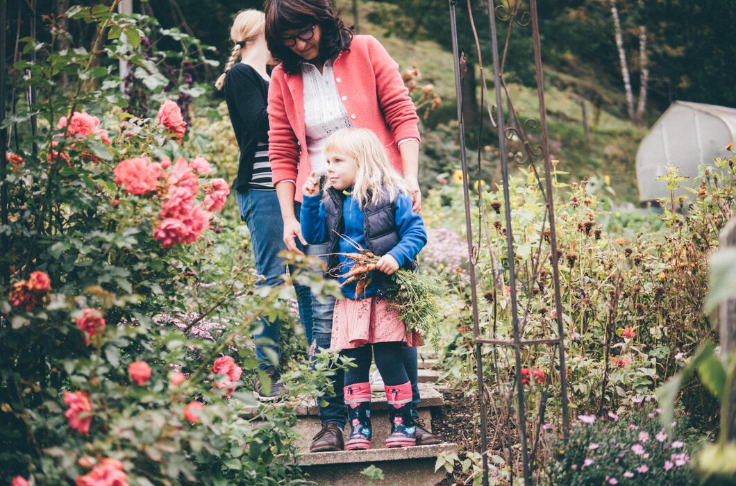 Frau und Kinder gehen durch den Garten | © Urlaub am Bauernhof Kärnten/ Daniel Gollner