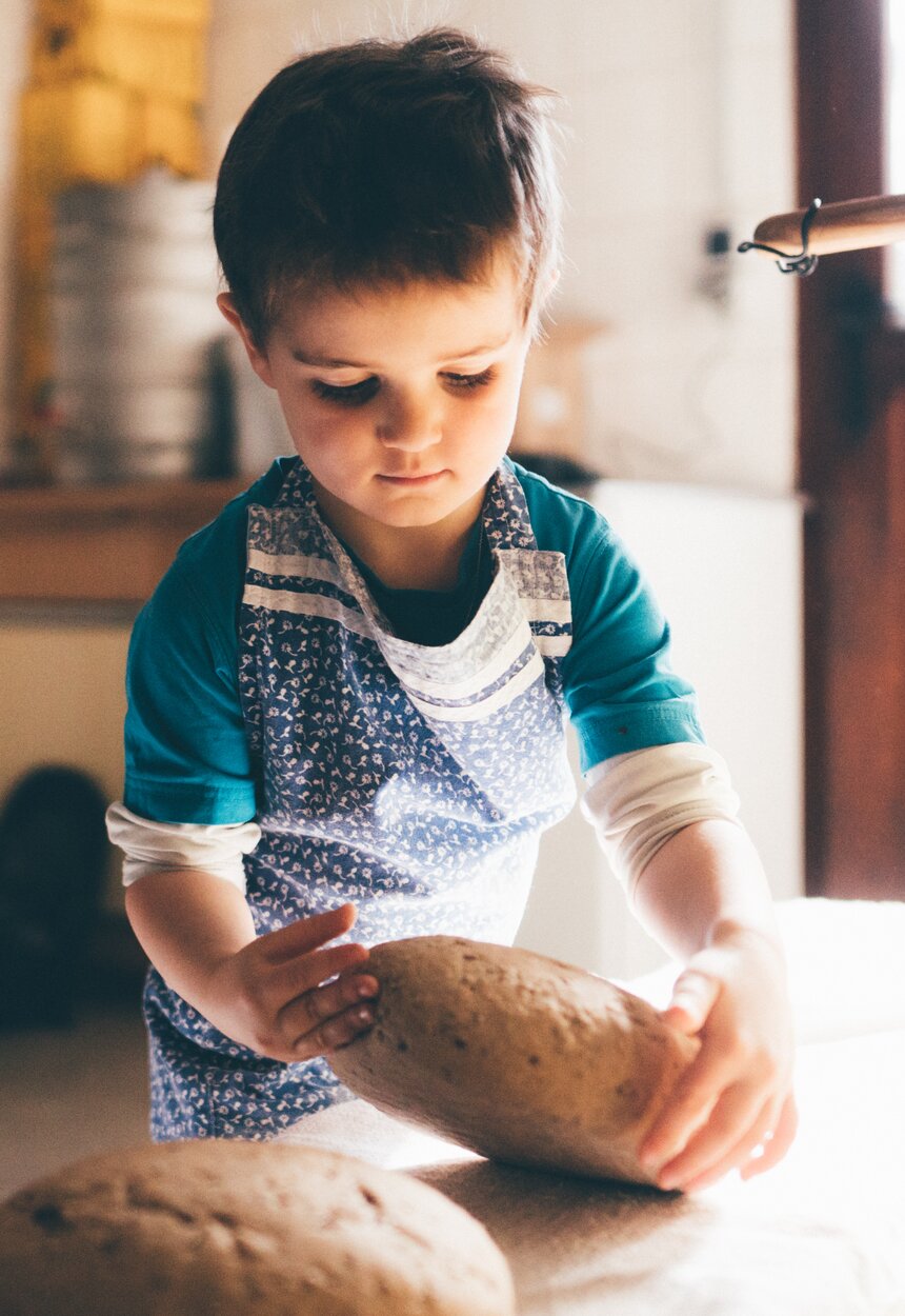 Bub nimmt das Brot von der Arbeitsplatte | © Urlaub am Bauernhof Kärnten/ Daniel Gollner