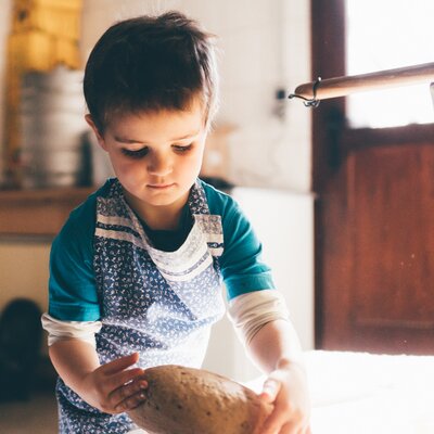 Bub nimmt das Brot | © Urlaub am Bauernhof Kärnten/ Daniel Gollner Bub nimmt das Brot von der Arbeitsplatte | © Urlaub am Bauernhof Kärnten/ Daniel Gollner