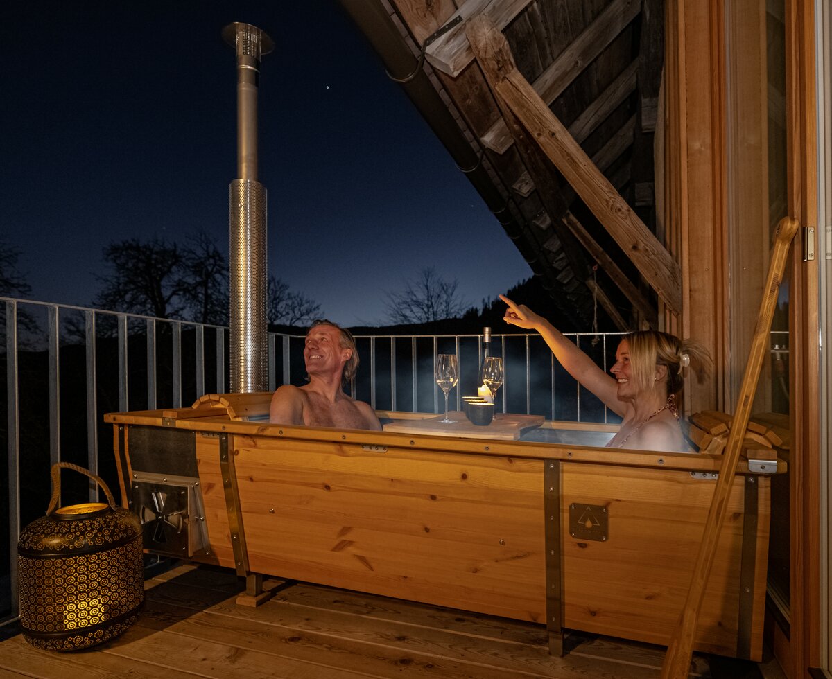 Paar sitzt in der Holzwanne am Balkon | © Urlaub am Bauernhof Kärnten/ Achim Mandler