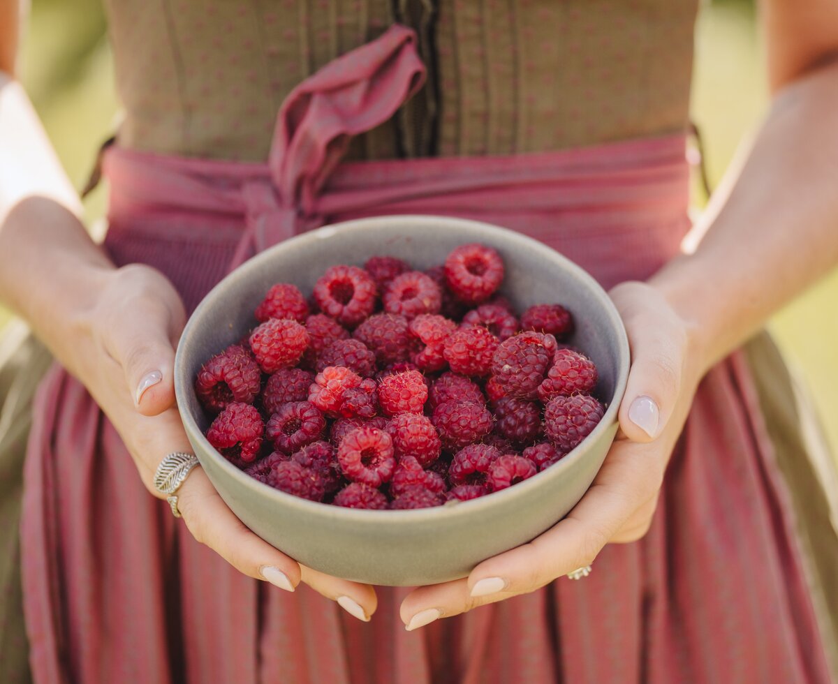 Frau mit Schale Himbeeren in der Hand | © Urlaub am Bauernhof Oberösterreich / Footprints Fotografie - cookingCatrin