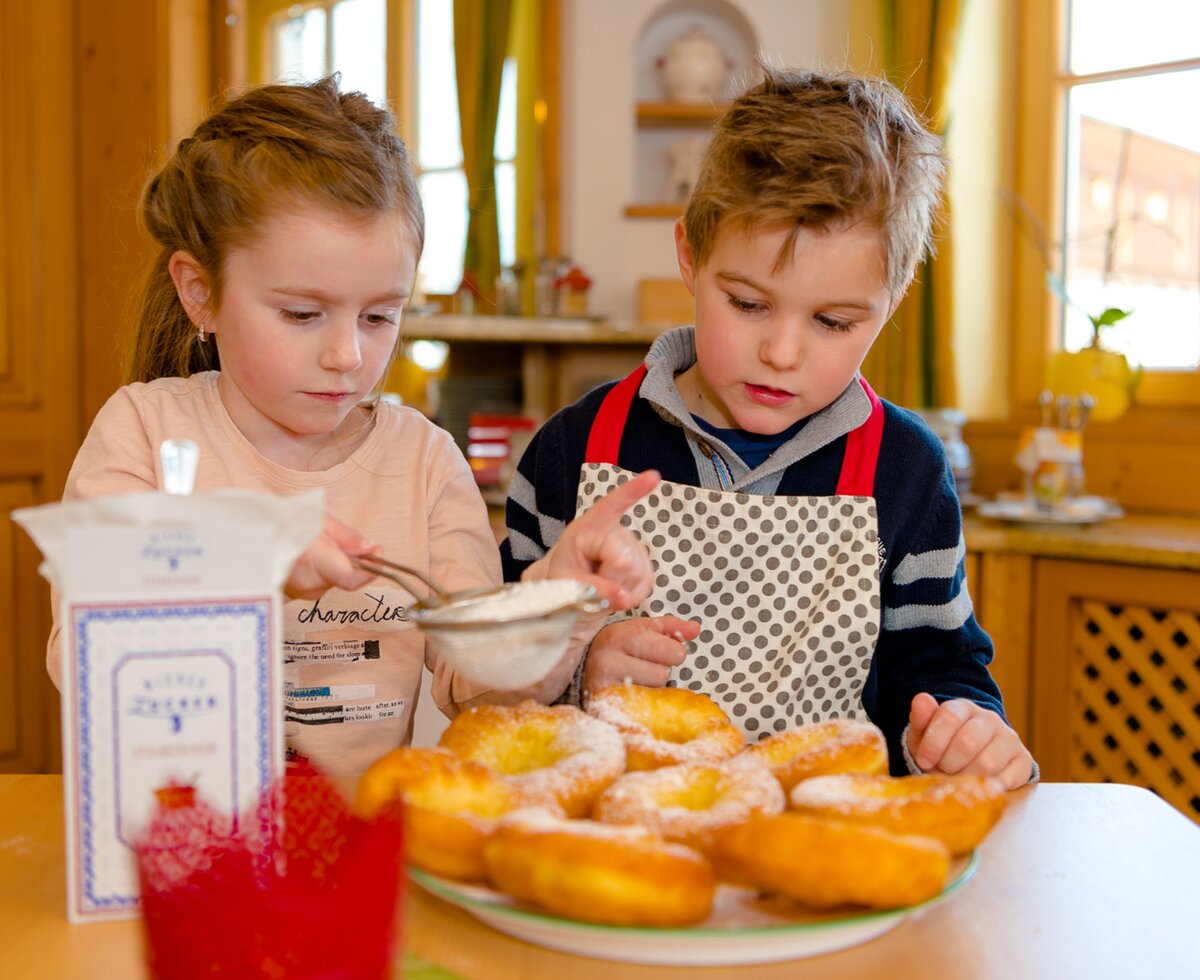 Zwei Kinder beim Zuckern der Krapfen, Steiermark | © Urlaub am Bauernhof Steiermark | Wolfgang Spekner