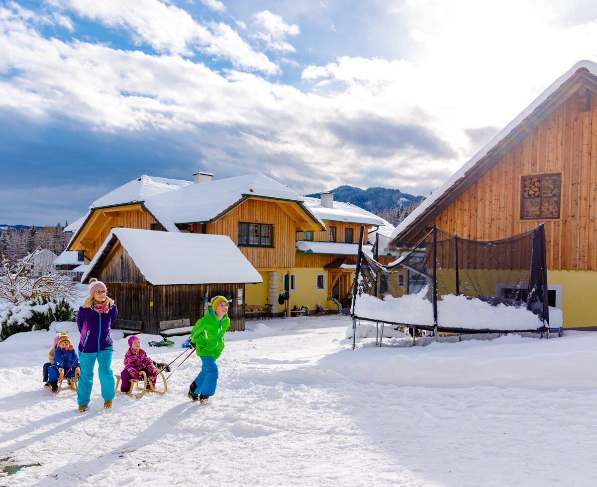 Mutter und Sohn ziehen die Schlitten mit den kleinen Kindern, Steiermark | © Urlaub am Bauernhof Steiermark | Wolfgang Spekner