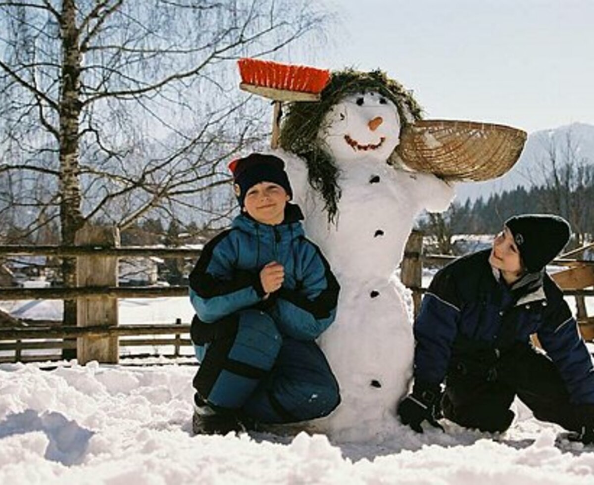 Zwei Buben neben ihrem selbst gebauten Schneemann, Steiermark | © Urlaub am Bauernhof Steiermark | Tom Lamm