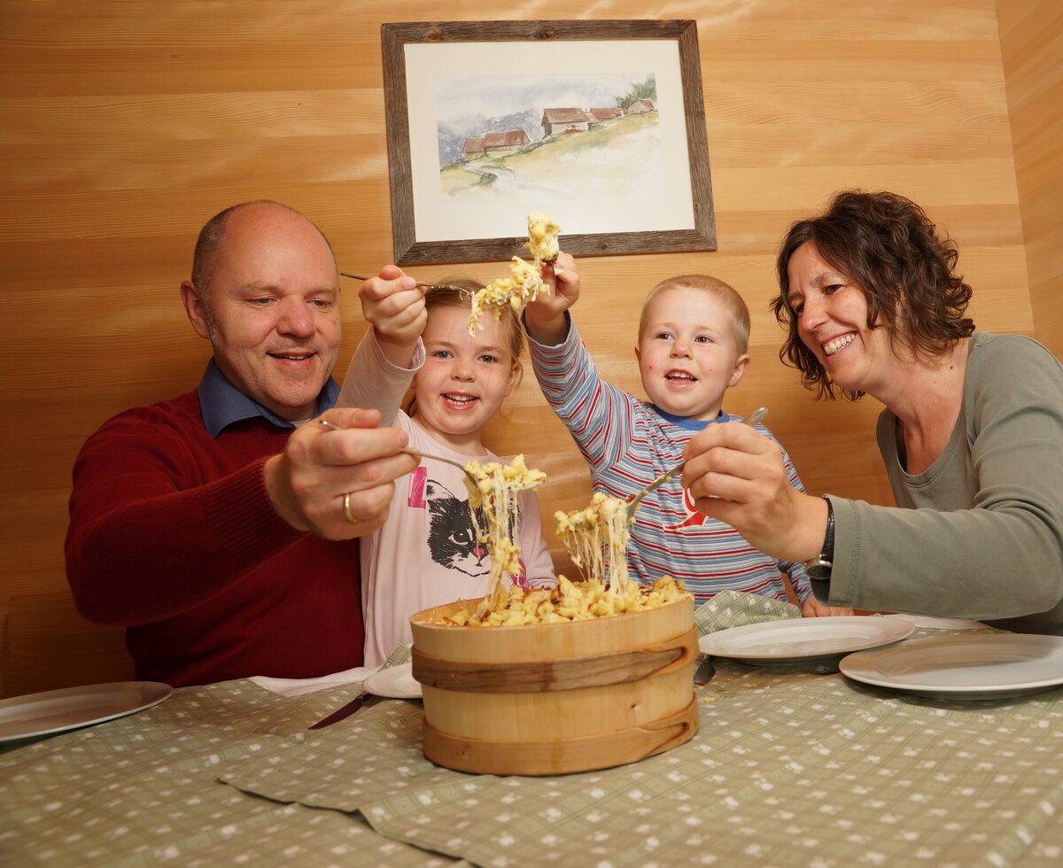 Familie beim Käsknöpfe essen | © Urlaub am Bauernhof Vorarlberg / Ludwig Berchtold Familie beim Käsknöpfe essen am Tisch | © Urlaub am Bauernhof Vorarlberg / Ludwig Berchtold