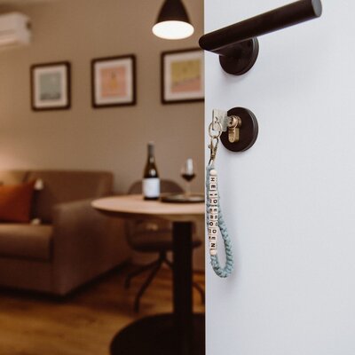 The key to your farmhouse, opening into a living area furnished with a sofa, a small table, and an air conditioning unit.