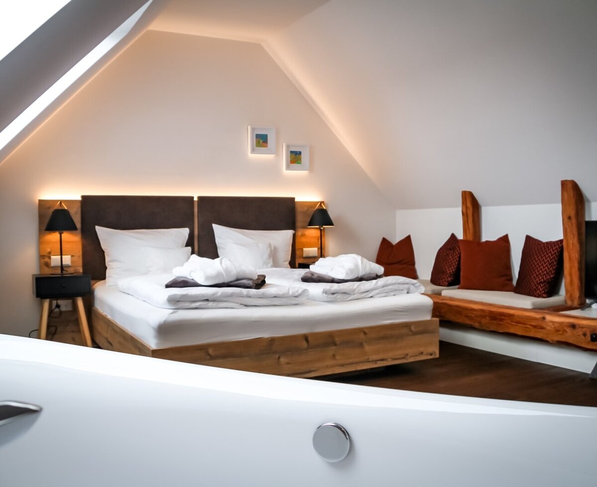 Farm House bedroom featuring a double bed, a built-in seating area with a television, and an in-room bathtub.