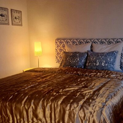 Double bedroom in the farmhouse featuring a patterned headboard, two bedside lamps, and decorative animal prints.