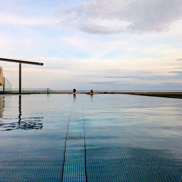 Infinity pool at the farmhouse with 32°C water temperature and lake view.