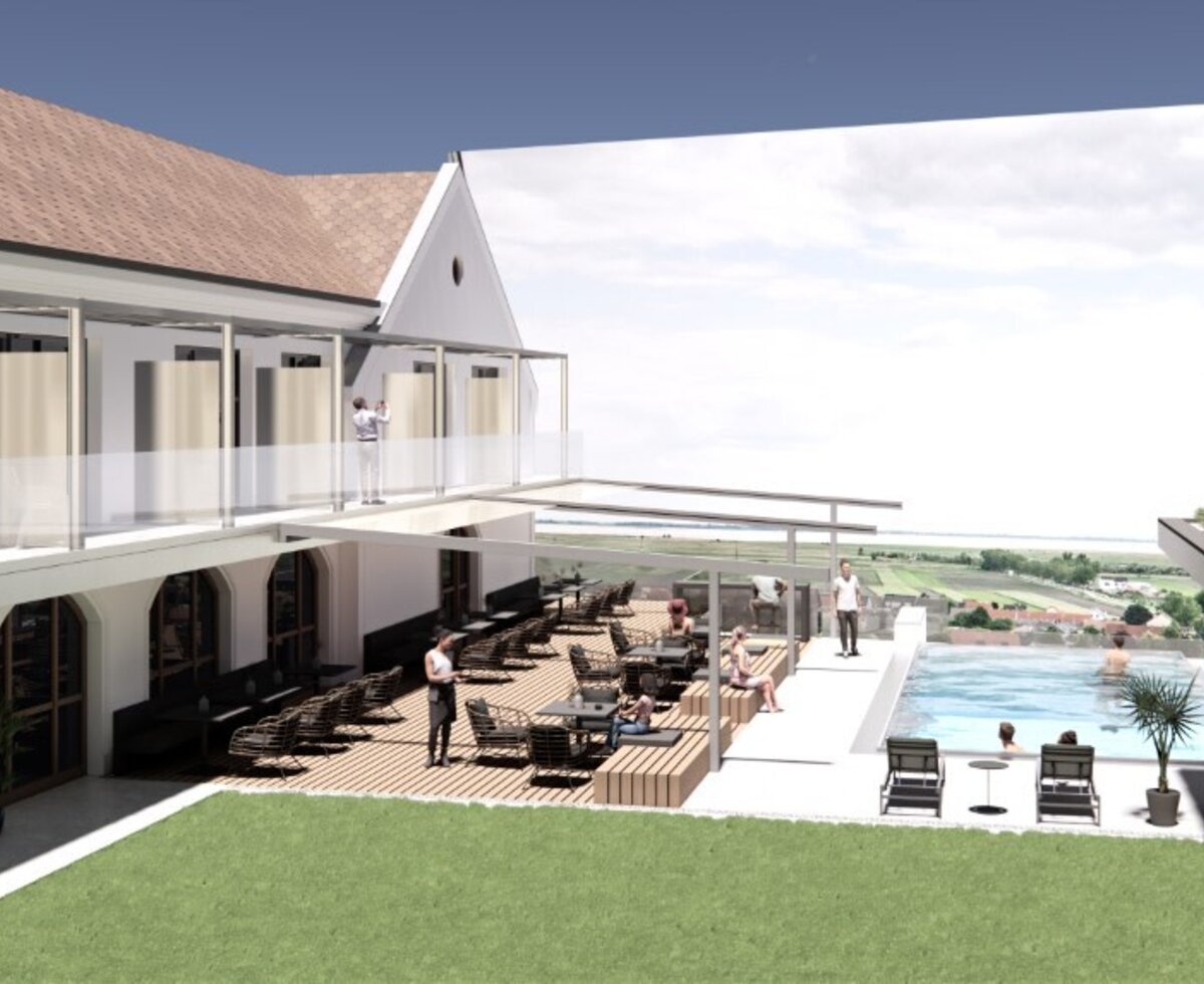 The outdoor terrace of the Haus with seating, a swimming pool, and balconies on the upper floor.