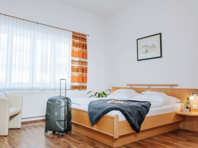 Bedroom in the Haus with a double bed, nightstand, reading lamp, armchair, and window.