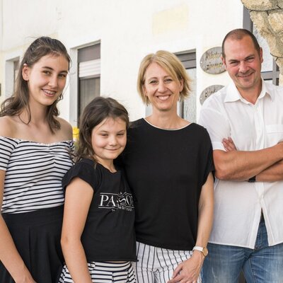The family hosts of the farmhouse, standing outside the property.
