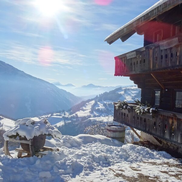 The Alpine Hut featuring a wooden balcony with a view of the snowy mountain landscape under a bright sun. The Alpine Hut featuring a wooden balcony with a view of the snowy mountain landscape under a bright sun.