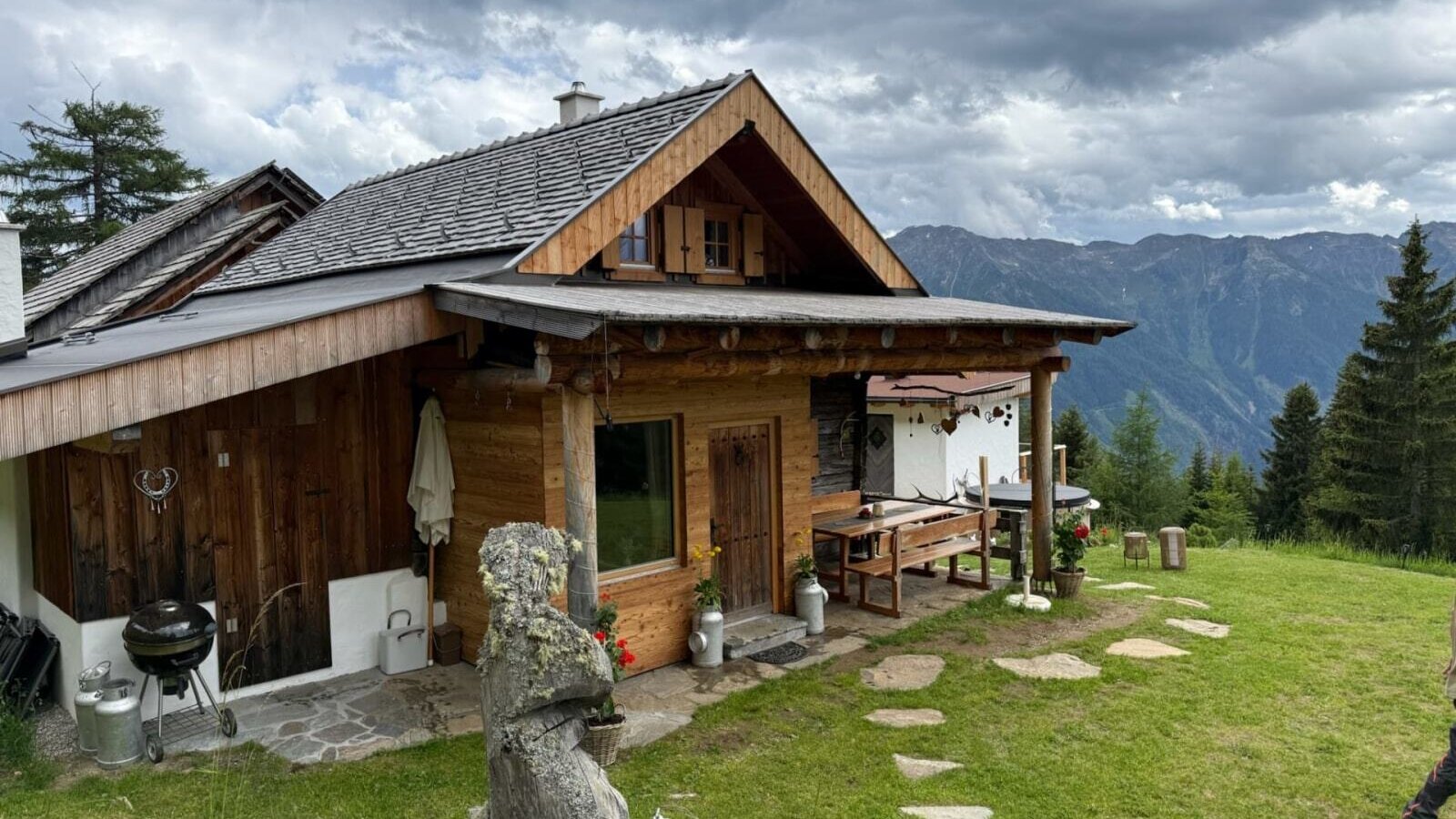 Rustic Alm featuring a cozy wooden terrace, outdoor barbecue area, and wide views of the surrounding mountains.