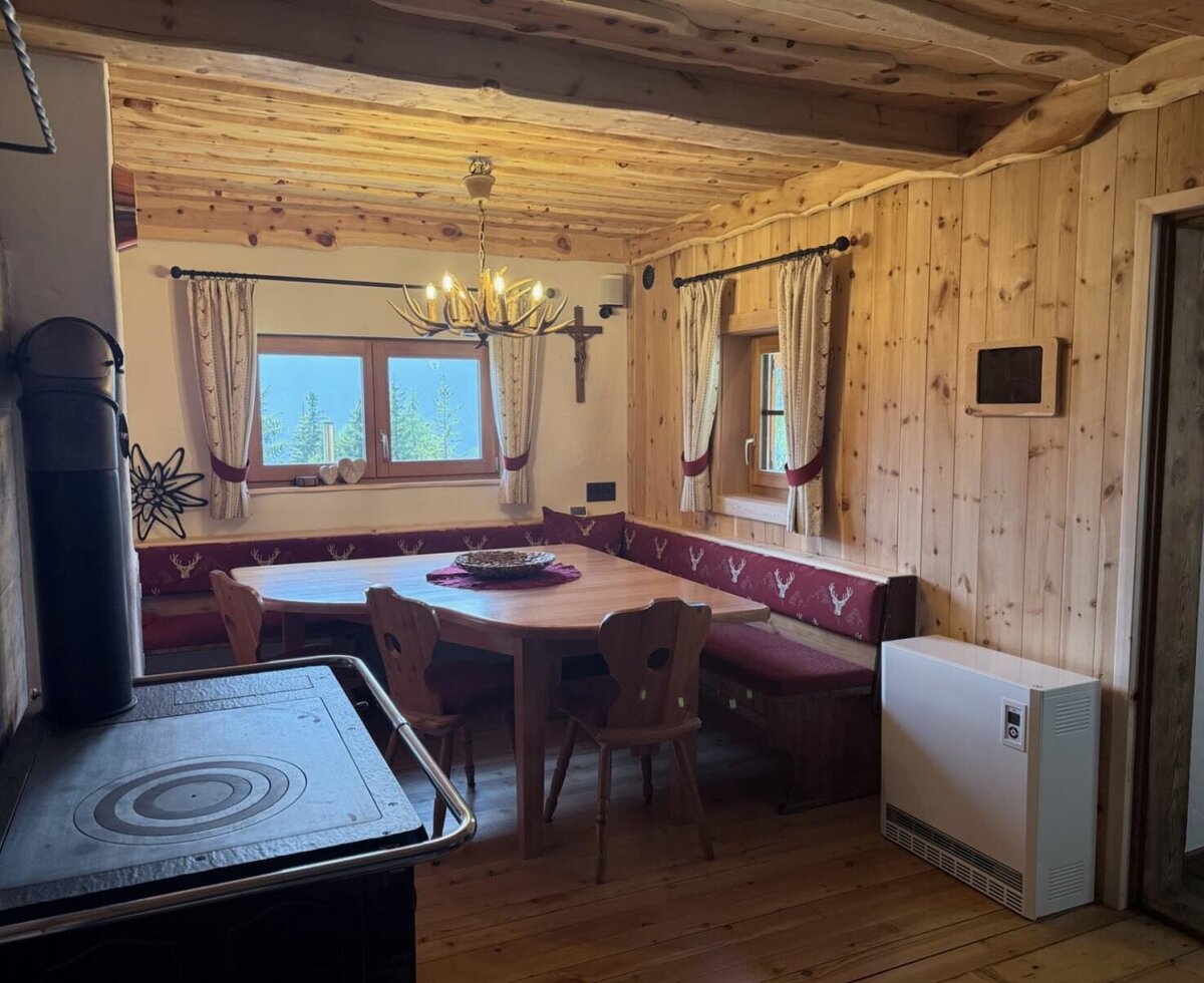The cosy kitchen-dining area offers a generous dining table, inviting corner seating and plenty of space for shared meals.