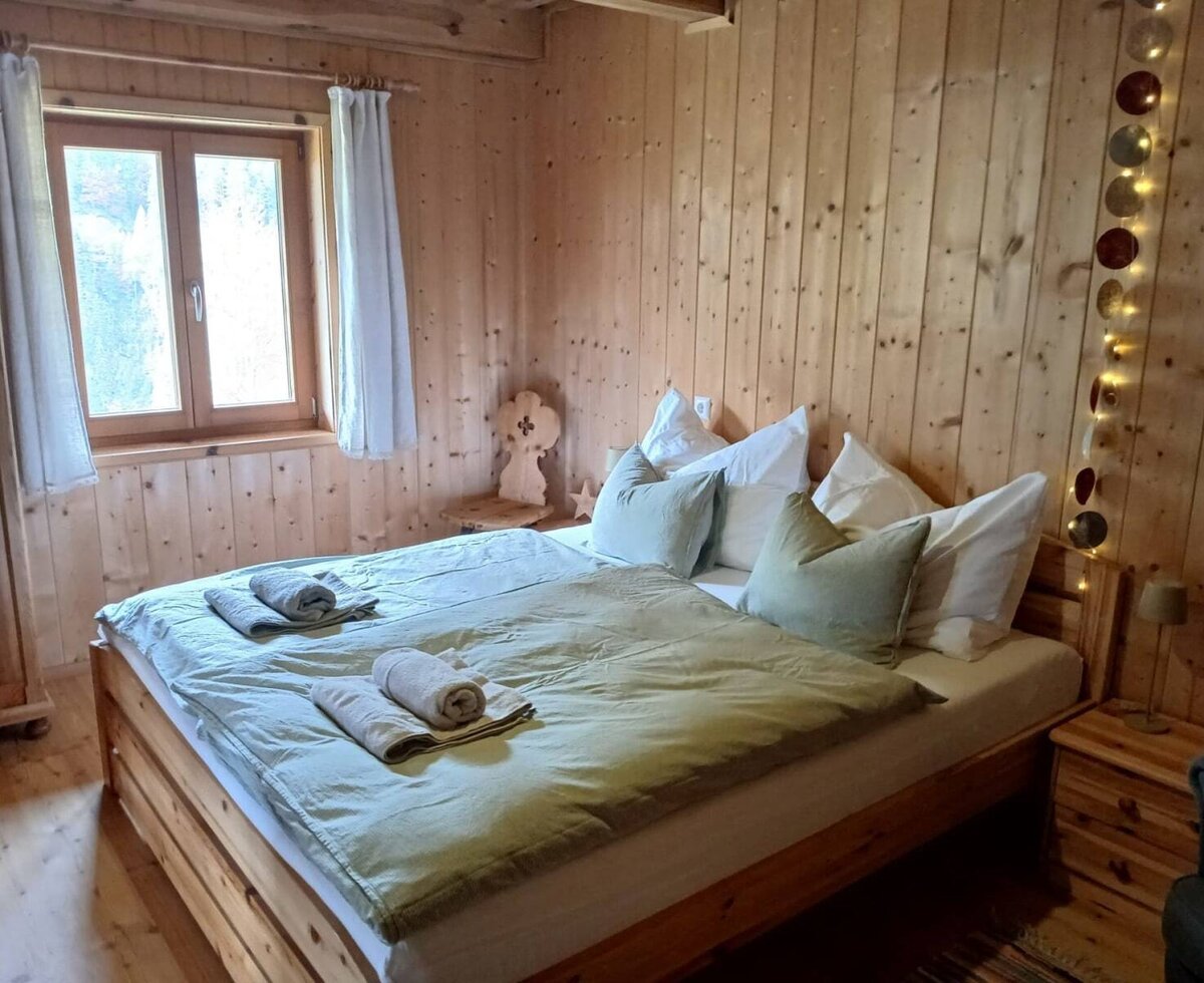 Bedroom in the Bed and Breakfast with wooden walls, a double bed, and bedside tables.