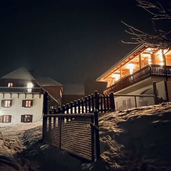 The illuminated vacation rentals at night, set against a snowy landscape with visible fencing.