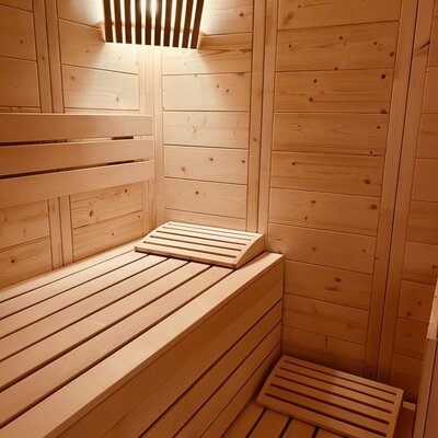 The vacation rental offers a private sauna with slatted wooden benches, a headrest, and a footrest.