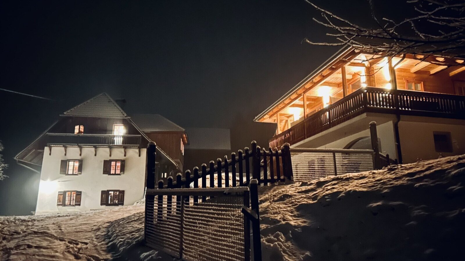 The illuminated vacation rentals at night, set against a snowy landscape with visible fencing.