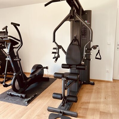 A fitness area in the vacation rental, equipped with a multi-gym machine and an exercise bike.