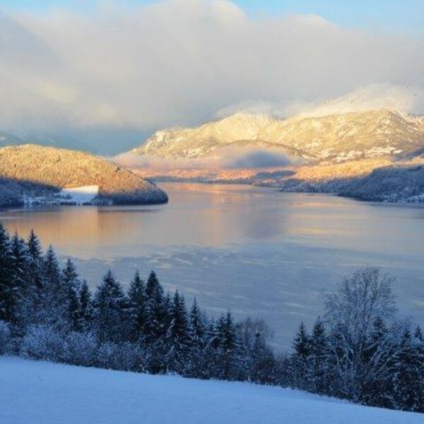 Panoramic winter view of the lake and snow-covered mountains surrounding the Farm House.