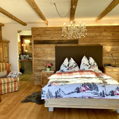 Spacious, rustic-luxurious bedroom in the chalet with double bed and access to en suite bathroom