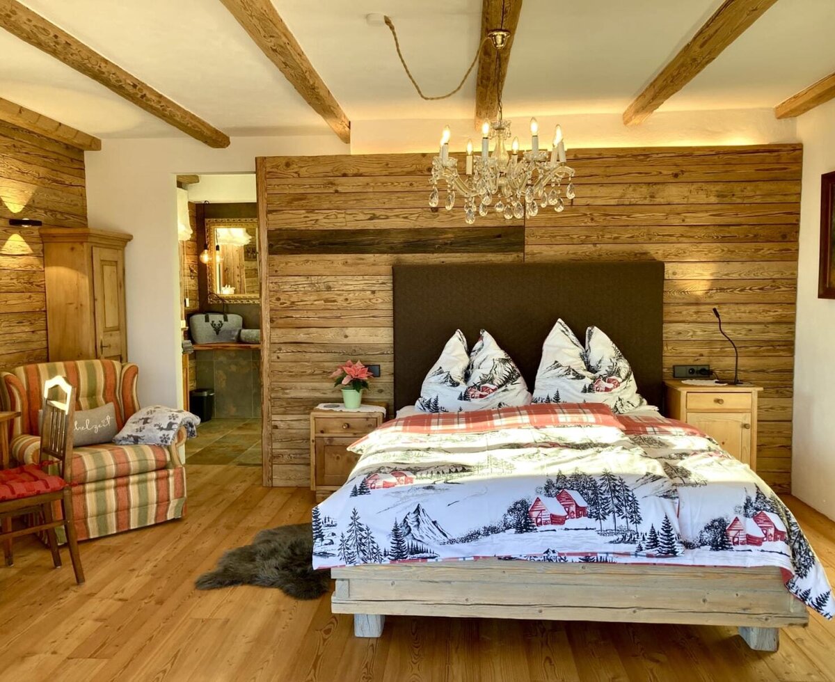 Spacious, rustic-luxurious bedroom in the chalet with double bed and access to en suite bathroom