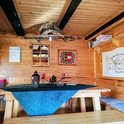Dining area of the Alm with a wooden table, wooden benches, and traditional decor.