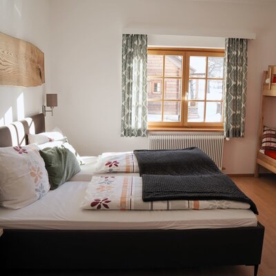 Family room in the farmhouse with a double bed and a bunk bed.