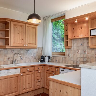 The fully equipped kitchen of the farmhouse, featuring wooden furnishings, a dishwasher, stove, and microwave.