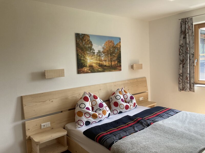 Double bedroom in the Farm House featuring a wooden bed with integrated bedside tables and a window.