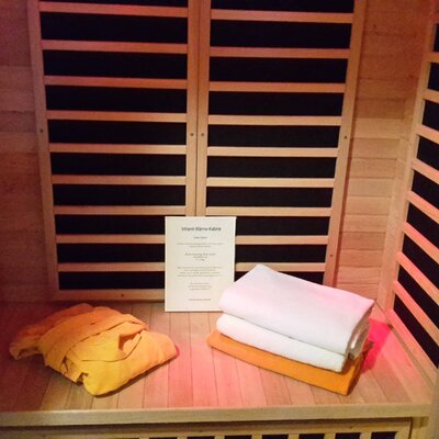 The Farm House's infrared sauna, ready for use with wooden benches, towels, and a robe.