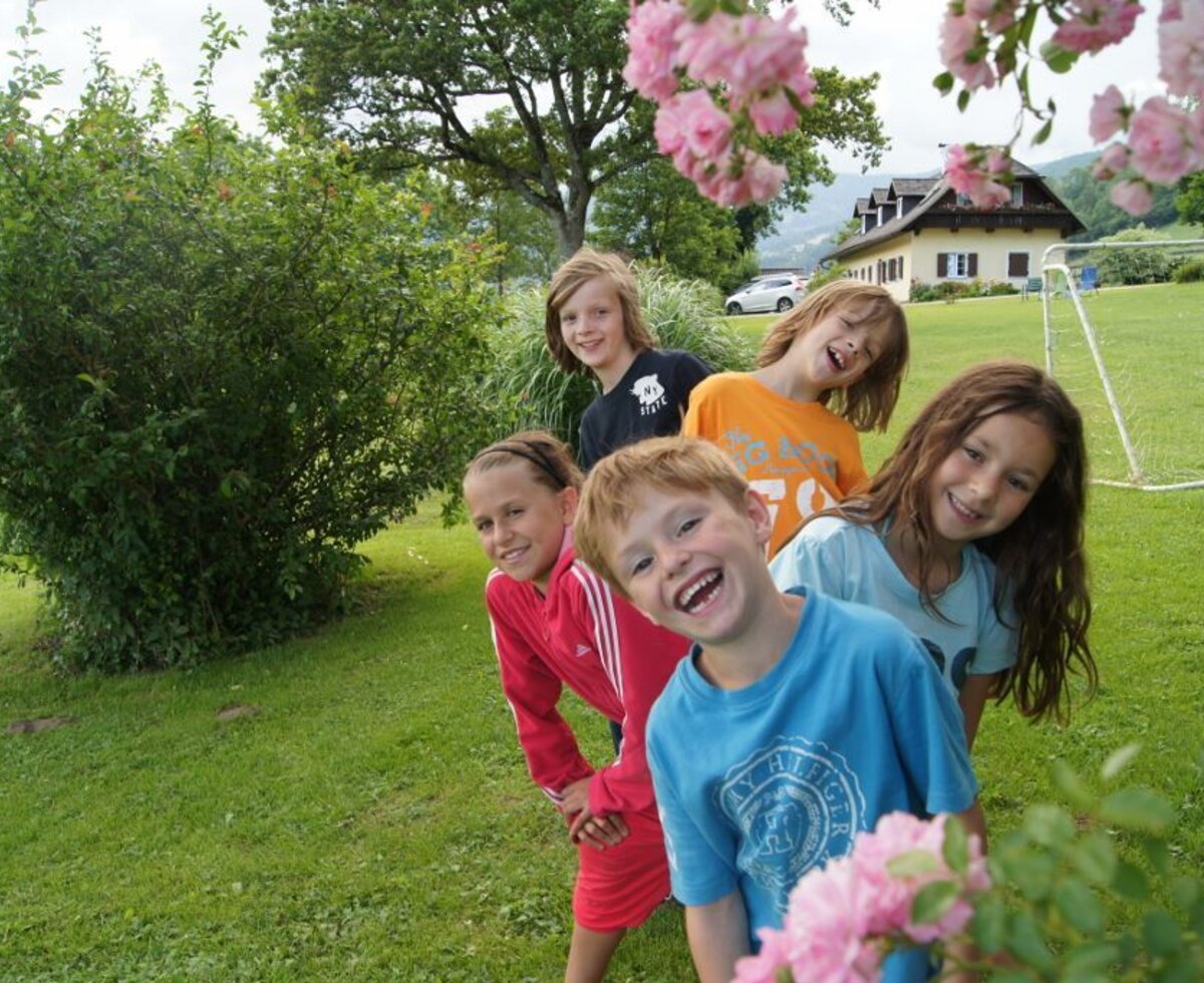 Children playing on the lawn at the Farm House, with a soccer goal and the farmhouse building in the background.