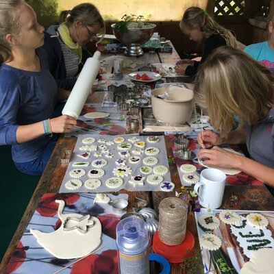 Guests at the Farm House participate in a creative activity, decorating cookie shapes with flowers and herbs.