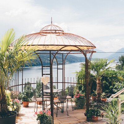 The Farm House features a covered patio gazebo with outdoor seating, offering views of the lake and surrounding mountains.