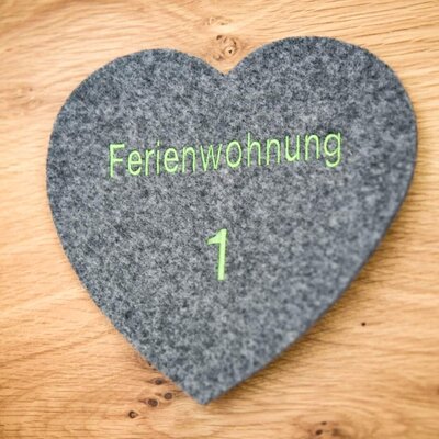 A charming heart-shaped felt sign marking apartment 1 at the farmhouse.
