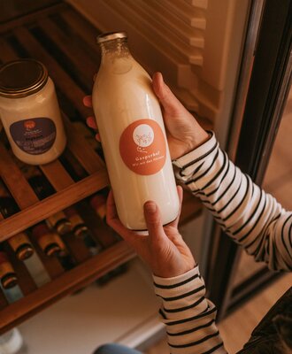 Bottle of dairy product from Gasperhof farm, being taken from the refrigerator.