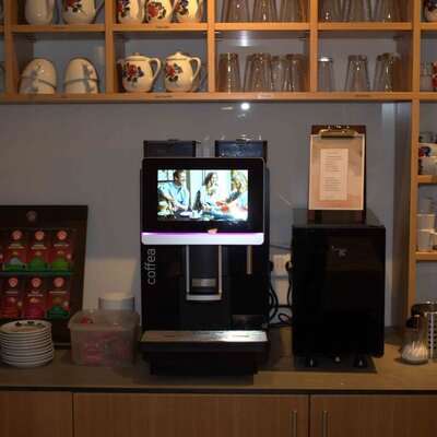 Coffee station in the farmhouse with a coffee machine, tea selection, and dishes.