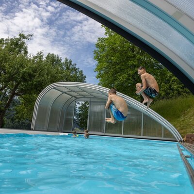 Outdoor swimming pool at the farmhouse with a retractable cover, offering swimming fun for children.