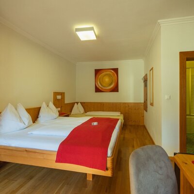 Double room in the farmhouse with a double bed, an additional single bed, and access to the bathroom.